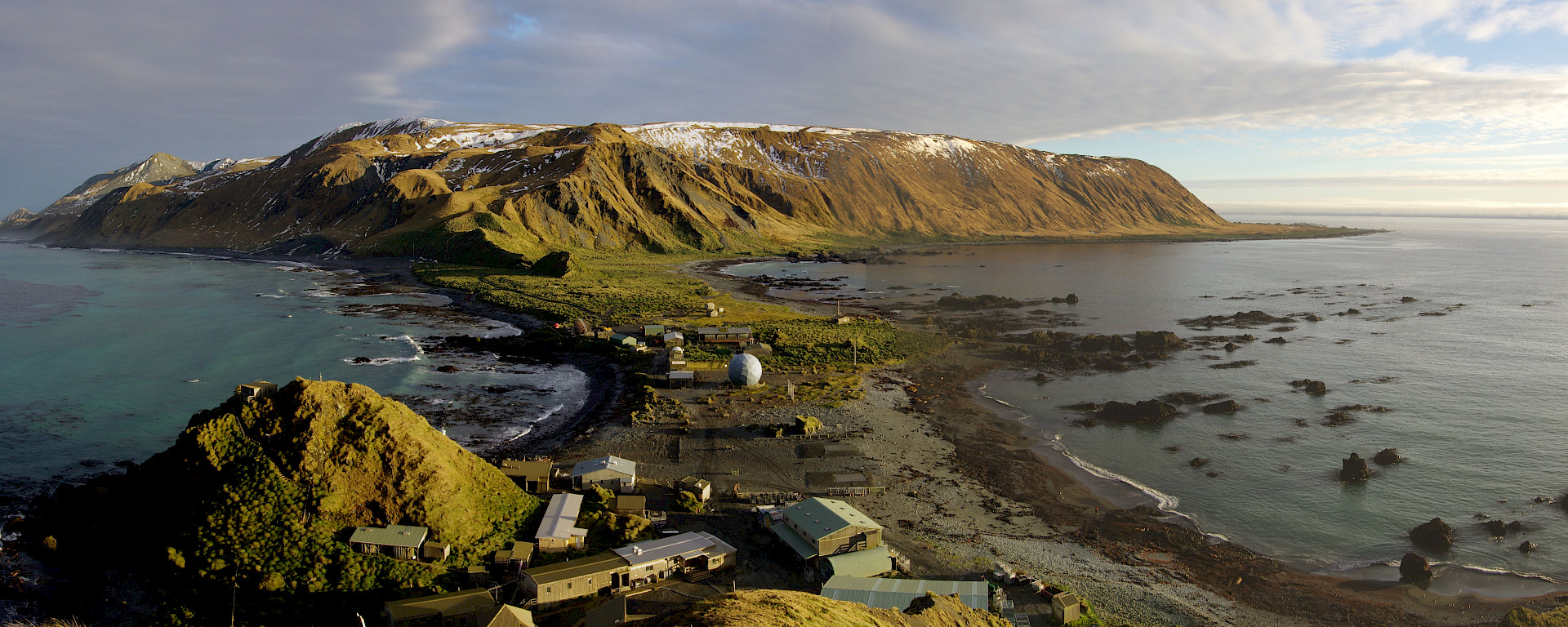 Station on isthmus and plateau bathed in golden afternoon sun in a view taken from on top of North Head