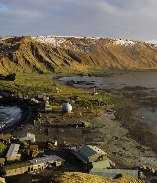 Station on isthmus and plateau bathed in golden afternoon sun in a view taken from on top of North Head