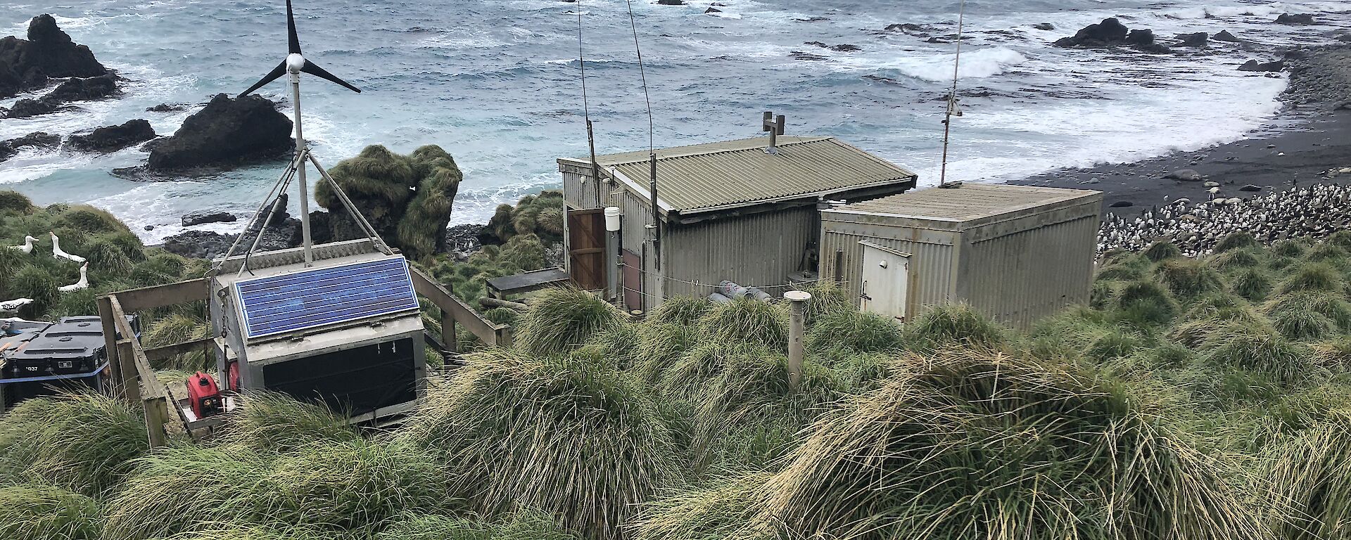 Small wooden field hut on cliff overlooking bay