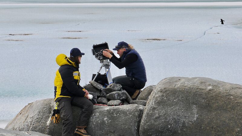 two scientists operate monitoring camera