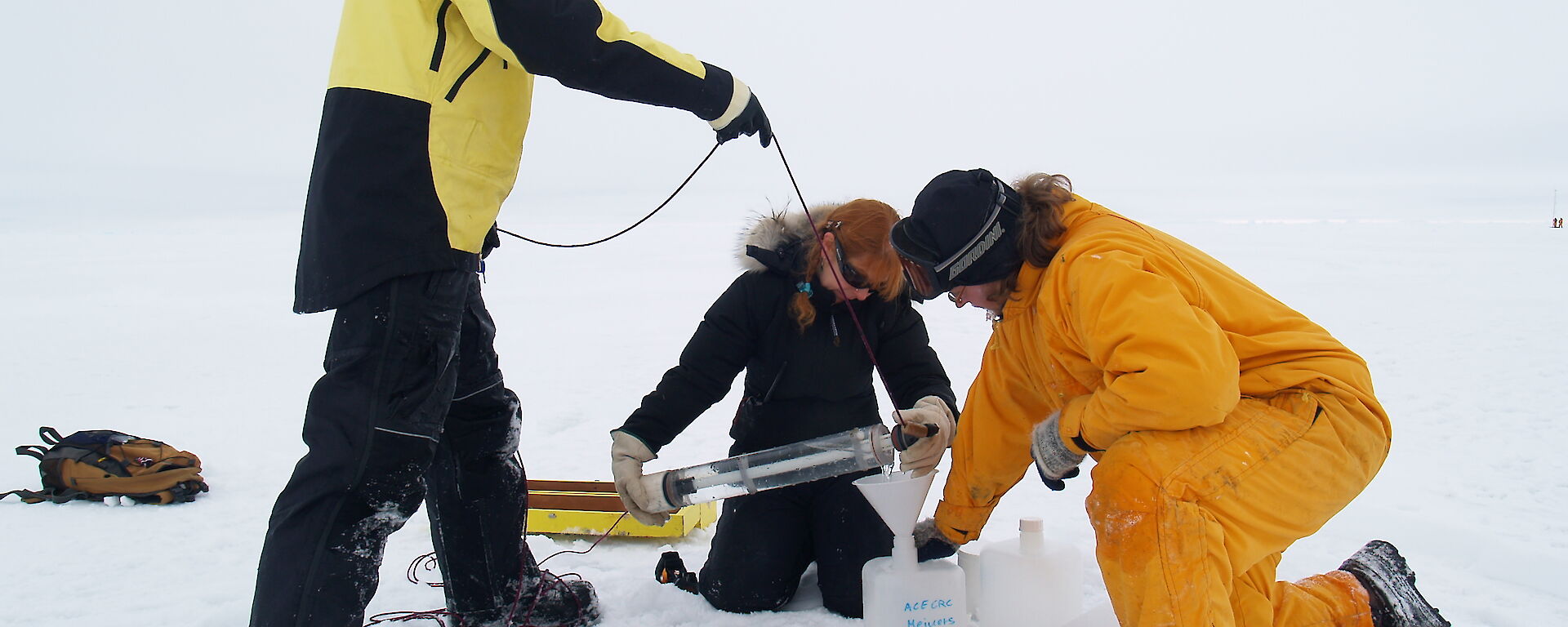 Scientists collecting water samples from under the sea ice.