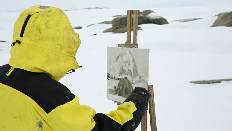 Arts fellow John Kelly at easel painting image of apple field hut