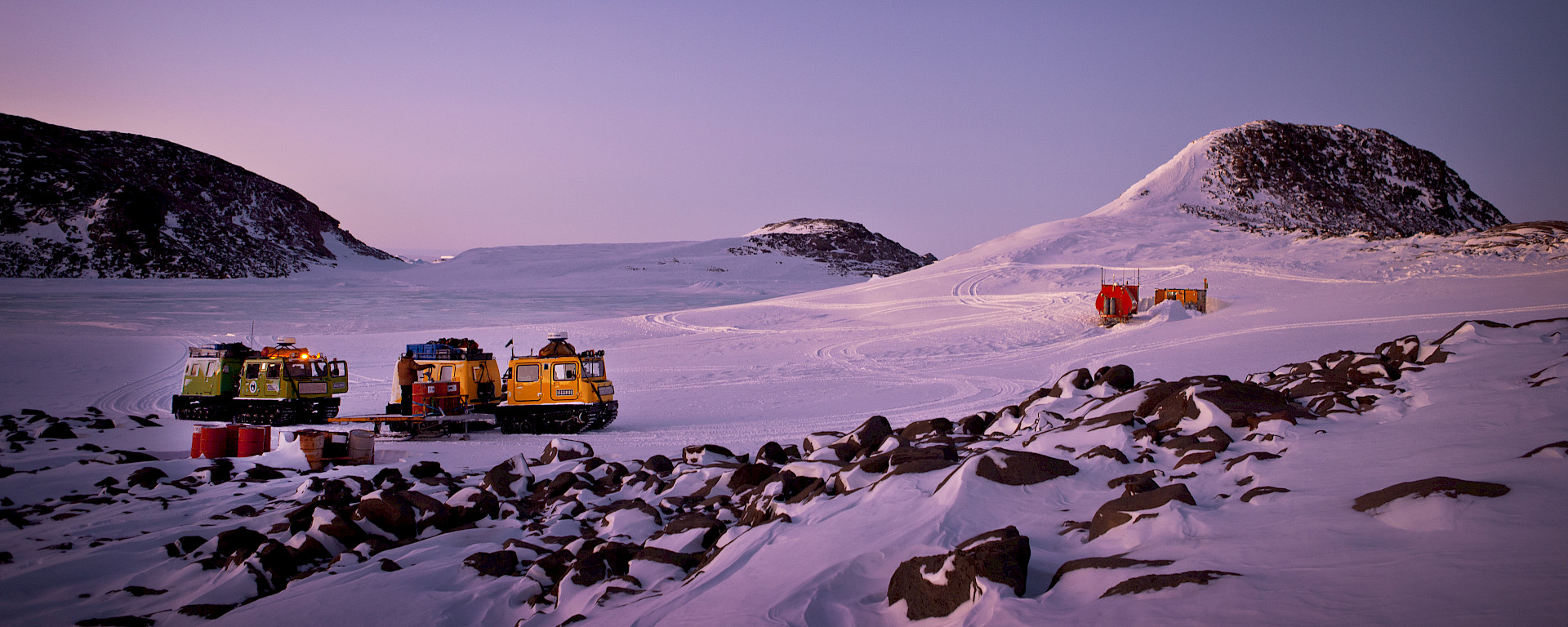 Two Hägglunds in evening light at field hut