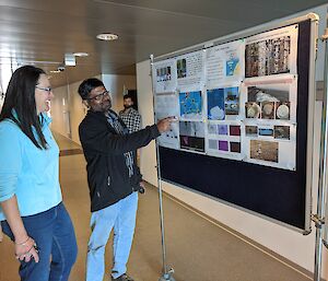 two people talk in front of poster