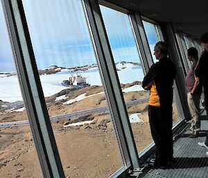 expeditioners looking at ship in harbour from inside station