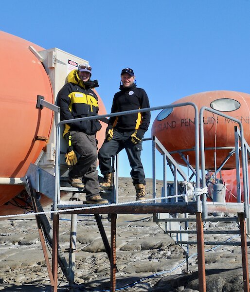 Two scientists standing in front of a field hut