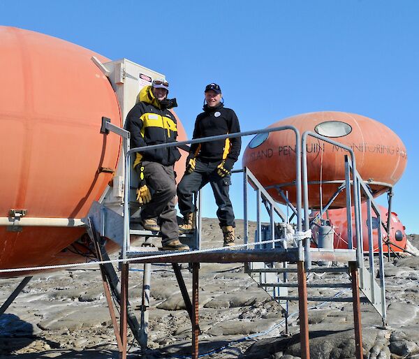 Two scientists standing in front of a field hut