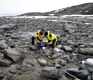 two scientists in a rocky landscape