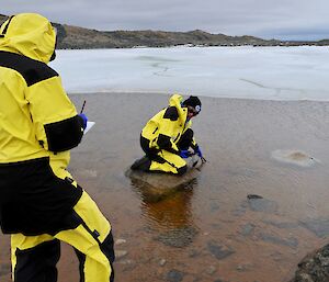 two scientists with probe in lake