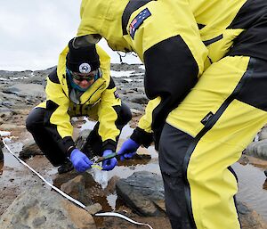 two scientists put sample in bag with trowel