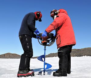 two men with large auger on sea ice