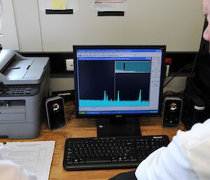 two people watch graph on computer screen