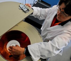 scientist puts sample into spectrometer