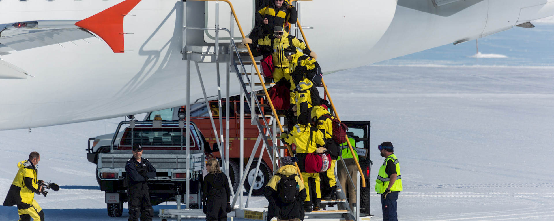 Passengers boarding gangway of aircraft on ice runway