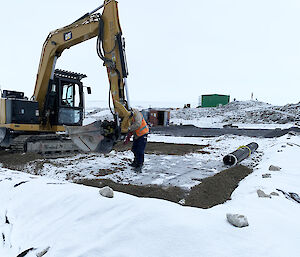 Excavator and its operator standing on top of the mega pile