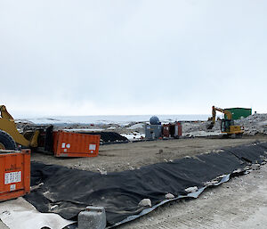 Two plant vehicles on a flattened mega pile