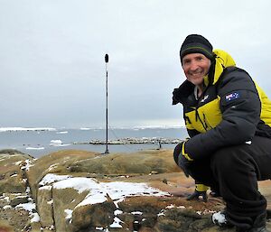 Sound artist with microphone on stand in the field with station in background