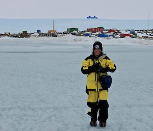 woman standing on sea ice with station behind