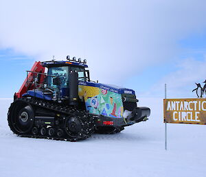 Tractor beside the Antarctic Circle sign