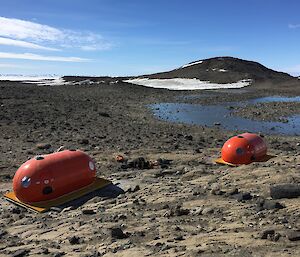 Two oval shaped huts on rocks