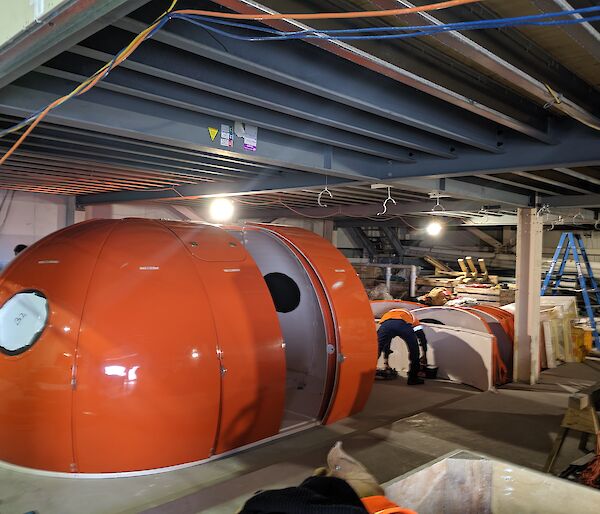 Inside view of workshop with round huts being built