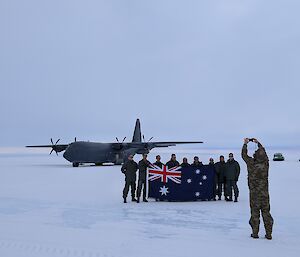 Group photos of air force personnel in front of a large aircraft on the ice runway