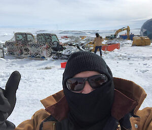 A self portrait of an expeditioner in front of pallets and plant machinery