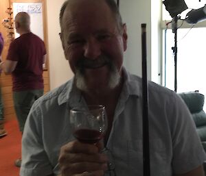 A portrait of a man holding a glass of wine