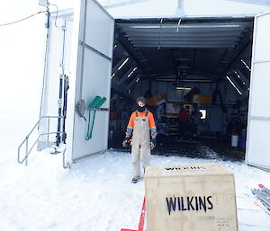 An expeditioner outside the workshop at Wilkins