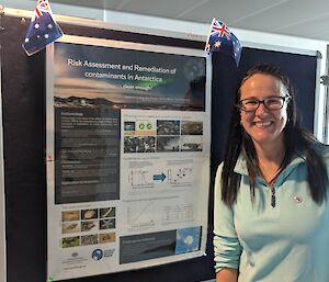 A woman standing next to an Australian Antarctic Program poster