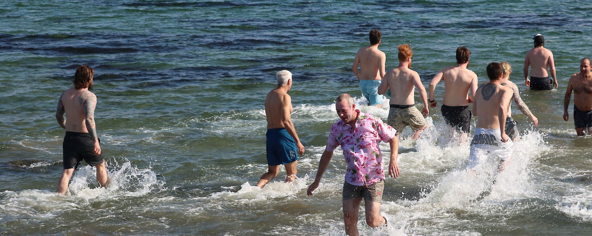 A group of expeditioners wade into the sea at Davis