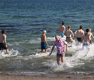 A group of expeditioners wade into the sea at Davis