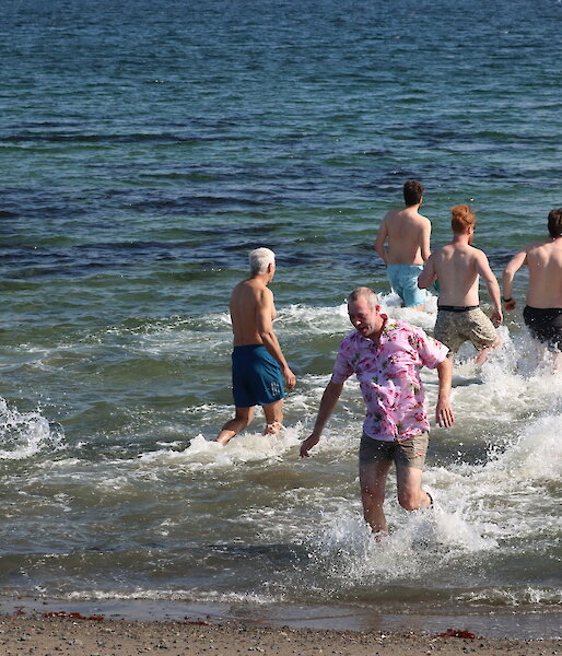 A group of expeditioners wade into the sea at Davis