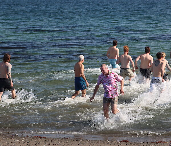 A group of expeditioners wade into the sea at Davis