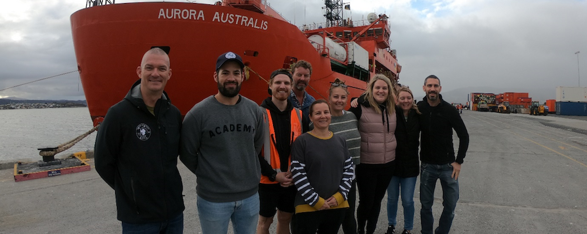 The hydrography team stop for a photo in front of the Aurora Australis ship in Hobart