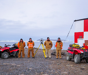 The ADF terrestrial survey team pose for a photo with their quad bikes and surveyors tripod
