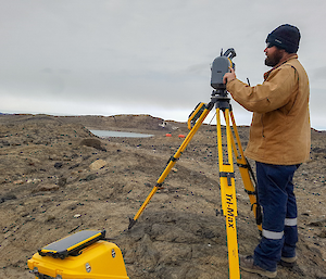 Surveyor setting up his scanner at the brown, rocky, proposed aerodrome ridge site