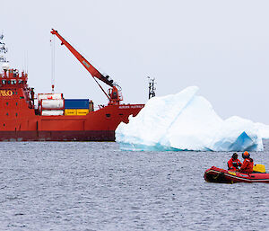 ship with iceberg and small inflatable craft