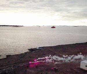 The 2020 Davis wintering party signal the Aurora Australis’ departure with a volley of flares as it heads into the distant ocean beyond