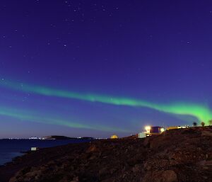 A real aurora australis casts a green glow across the blue night sky at Davis