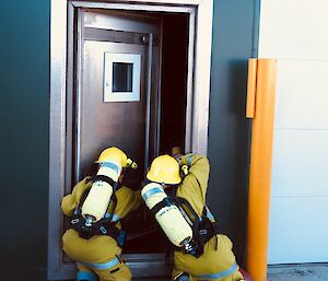 Two Fire Team members practice a door entry firefighting technique