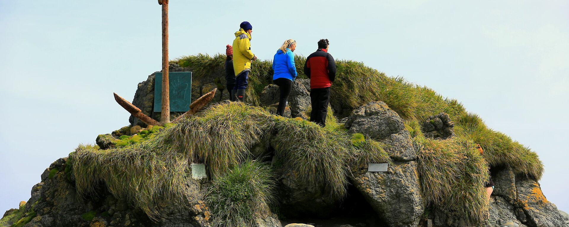 Three expeditioners standing on large rock stack