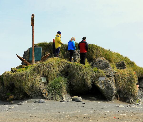 Three expeditioners standing on large rock stack