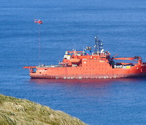 Helicopter collecting a slung load from the ship