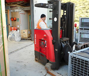Using a forklift an expeditioner moves a load into the green store