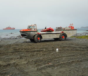 Amphibious truck with inflatable rubber boat loaded on top