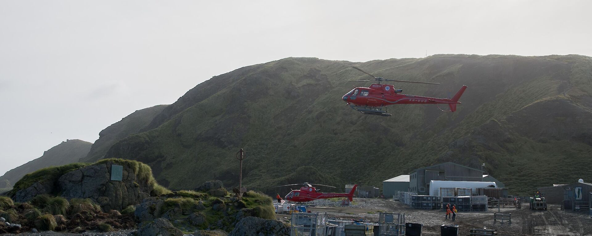 Two helicopters in flight over the station