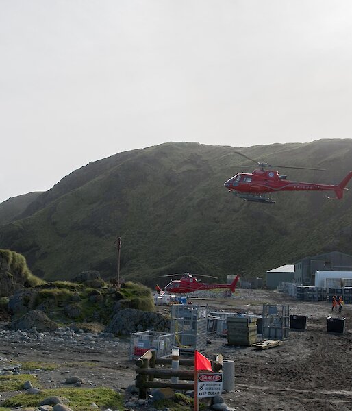Two helicopters in flight over the station