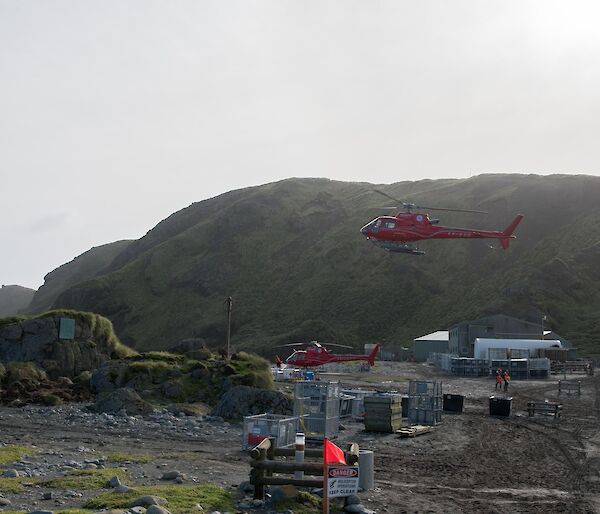 Two helicopters in flight over the station