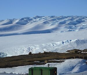 Bright sunlight on the hills behind station